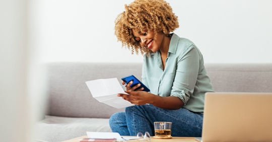 woman smiling looking at ac bill